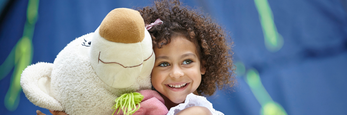 little girl cuddling teddy bear