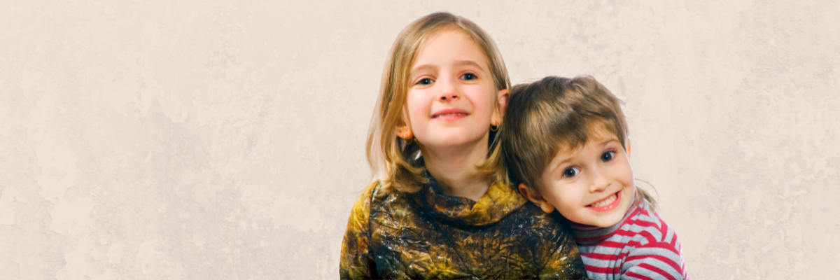 A boy and a girl smile at the camera