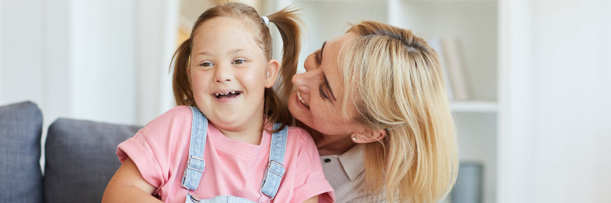 smiling girl being hugged by a woman